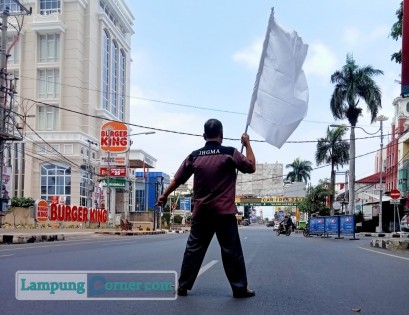 Salah satu anggota IHGMA Lampung mengibarkan bendera putih tanda menyerah di Jalan Raden Intan, Selasa (10/8/2021). FOTO: Dok IHGMA