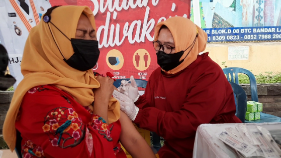 Salah satu pedagang Pasar Bambu Kuning saat divaksinasi, Rabu (20/10/2021). Foto: Istimewa