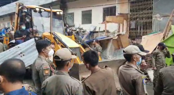 Terlihat alat berat saat menertibkan lapak PKL Bambu Kuning di Jalan Bukit Tinggi, Kamis (30/12/2021). Foto: Sulaiman