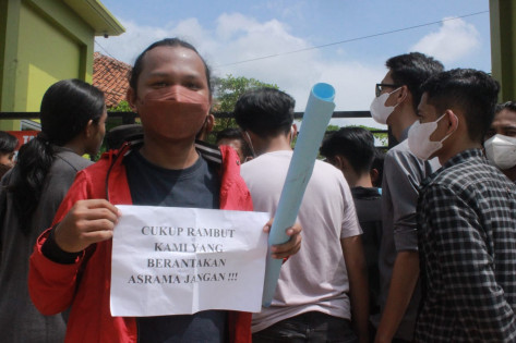 Salah satu peserta aksi yang menunjukan tulisan satire atas kebijakan sekolah. Foto: Istimewa