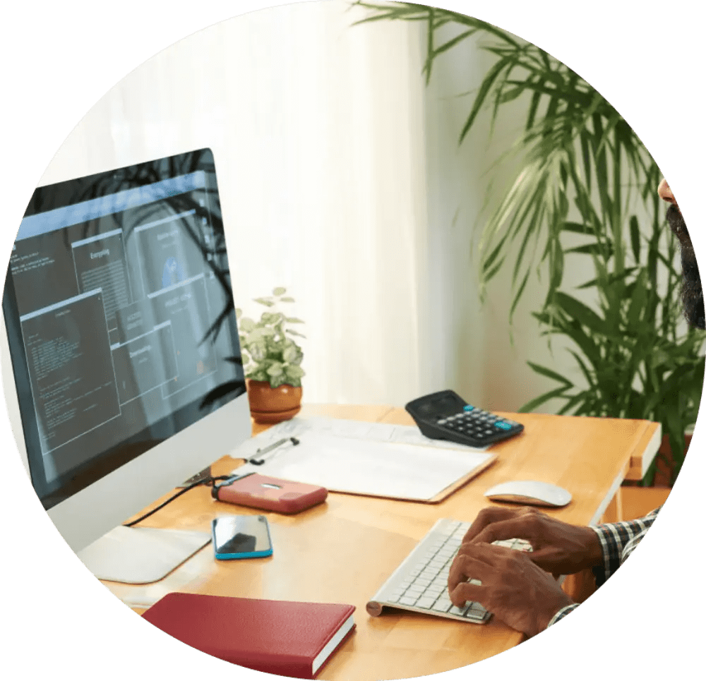 Person coding on a desktop computer.
