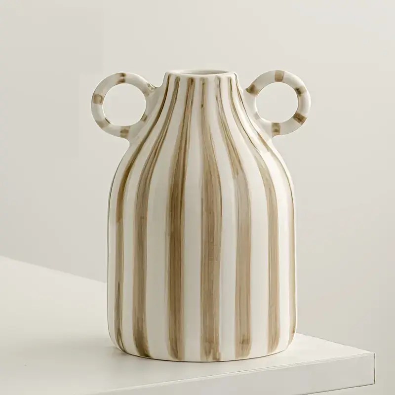 Modern striped ceramic vase with dual ring handles in neutral tones, minimalist home décor piece.