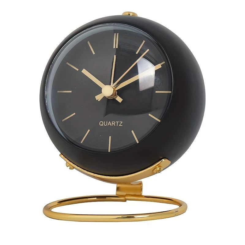 Round black desk clock with gold frame and luminous hands, styled with a sleek Nordic-inspired design and circular gold base.