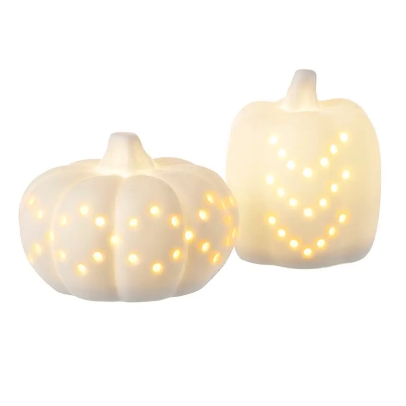 Two cream ceramic pumpkins with soft glowing LED lights