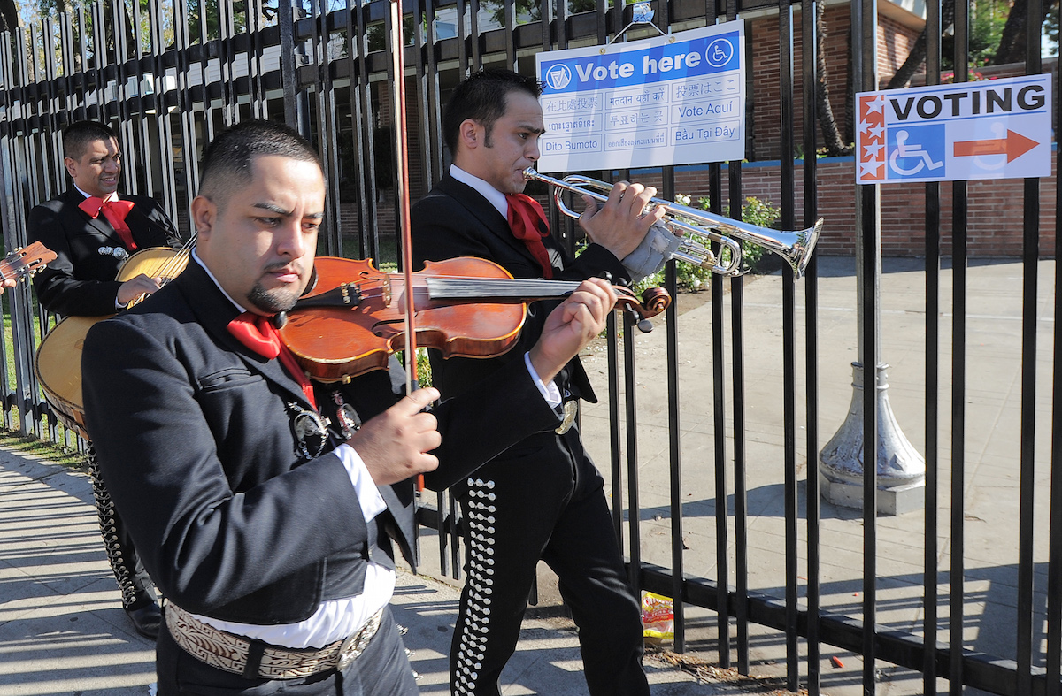 Mariachi musicians sing and play as they go from house to house to encourage people to come to vote on election day at the Sun Valley's Latino district, Los Angeles County, on November 6, 2012 in California.AFP PHOTO /JOE KLAMAR (Photo credit should read JOE KLAMAR/AFP/Getty Images)