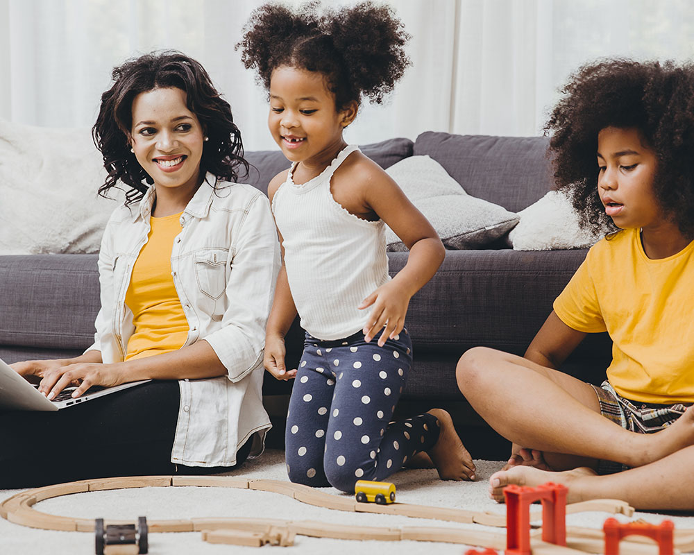 Mother checking computer with two daughters