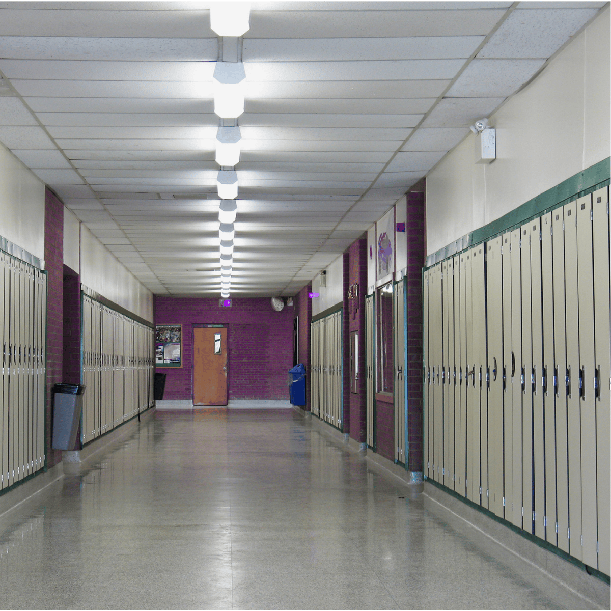 An empty school hallway with the lights on
