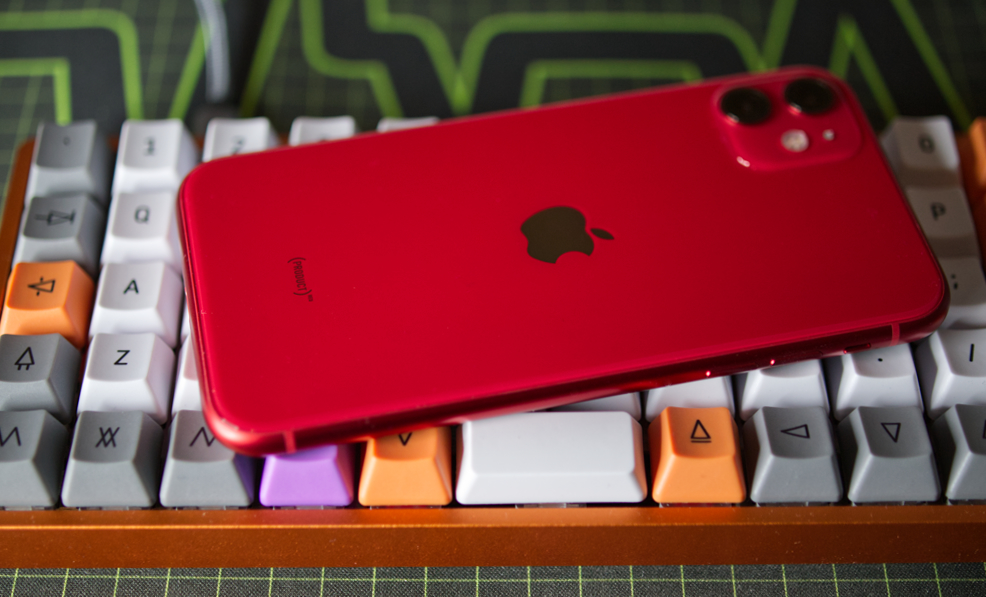 iPhone 11 in Product Red color on top of keyboard
