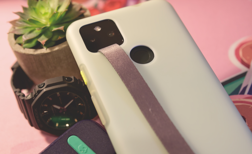 Google Pixel 5a with Google's case and a few background objects.