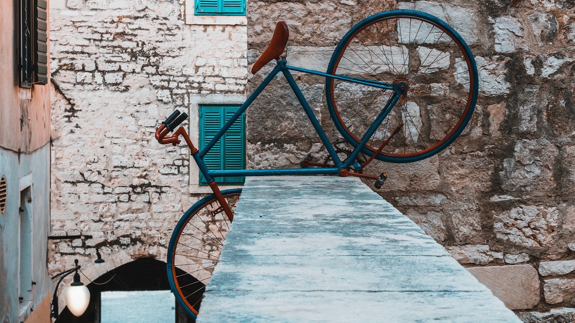 Neurodivergent Therapy in Durham NC | Painted blue bicycle perched at unusual angle on stone wall