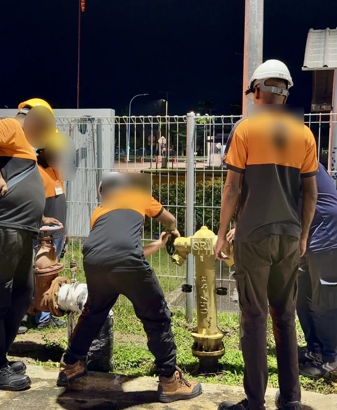 Technicians operating an accessible fire hydrant as part of system preparation and comparison at an industrial site in Penang.