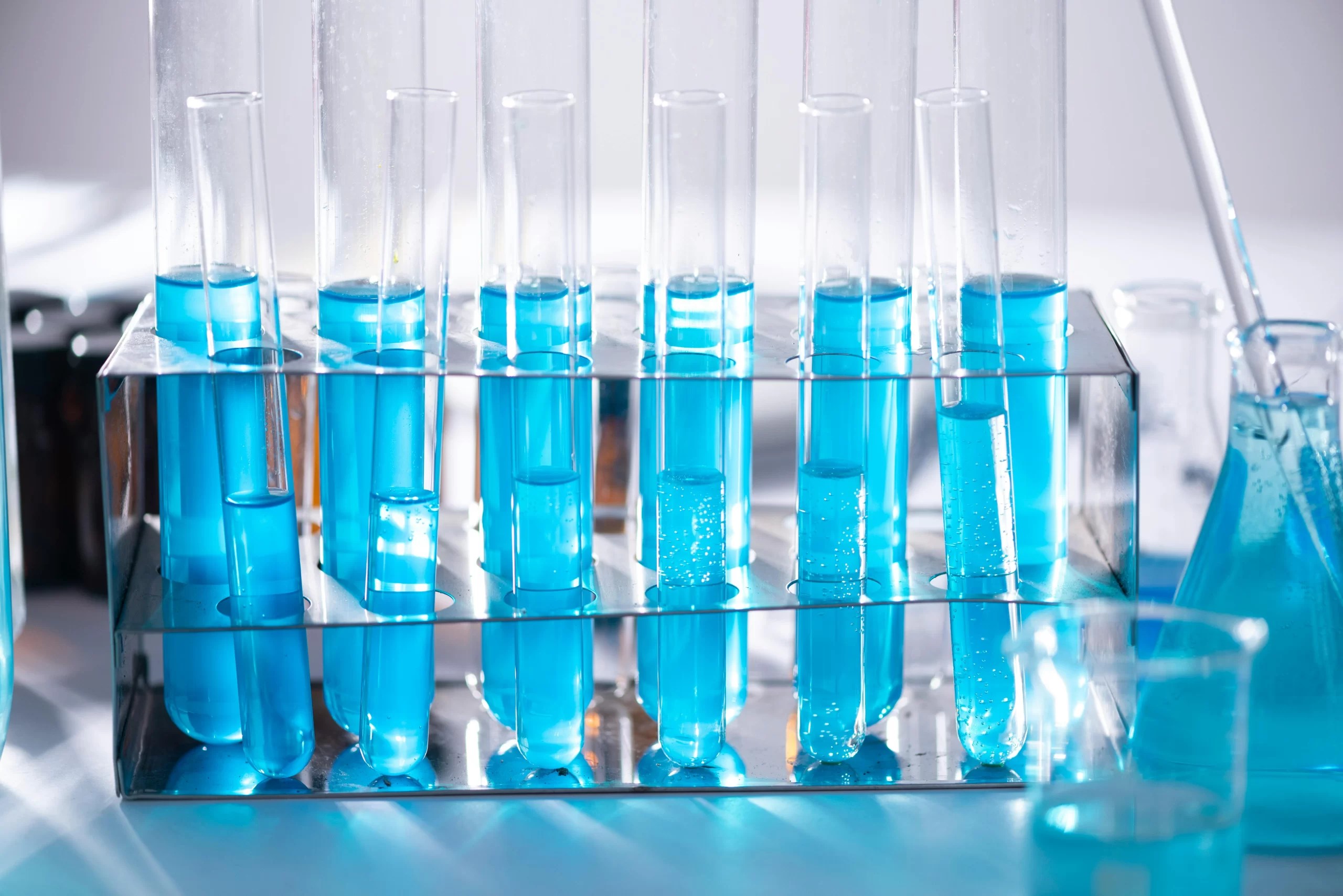 Small and large test tubes full of blue liquid