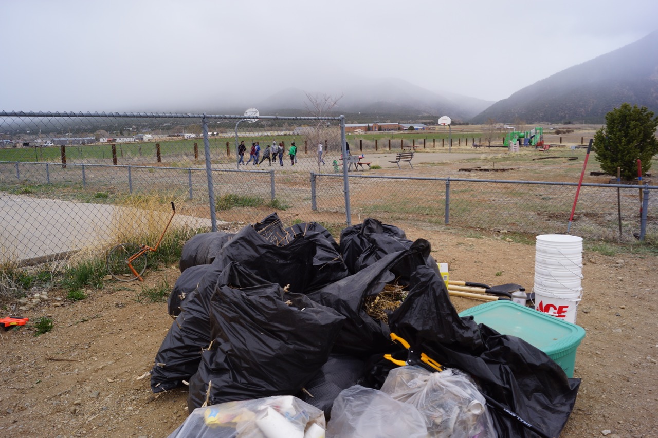 15 Bags of trash and invasive weeds removed, happy kids play in the background after a good morning of work, Photo by Claire Coté