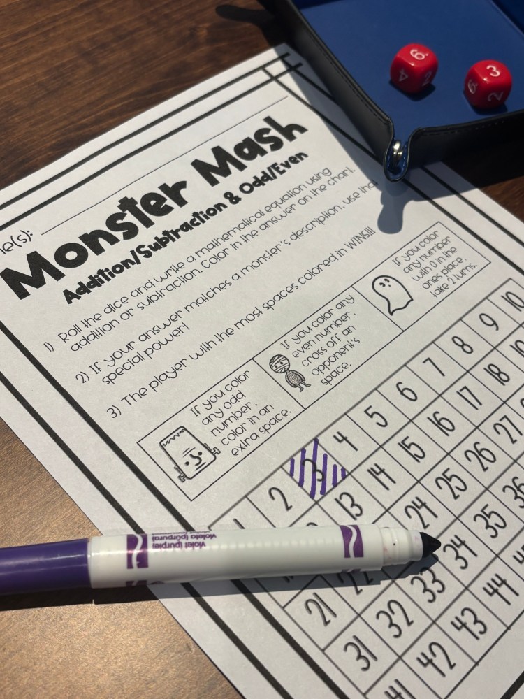 A tabletop game sheet titled 'Monster Mash' featuring mathematical operations and a grid for coloring, accompanied by two dice and a purple marker.