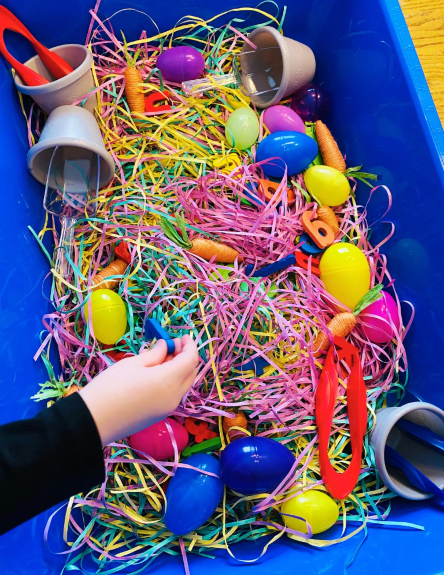 preschooler digging for letters in a sensory bin