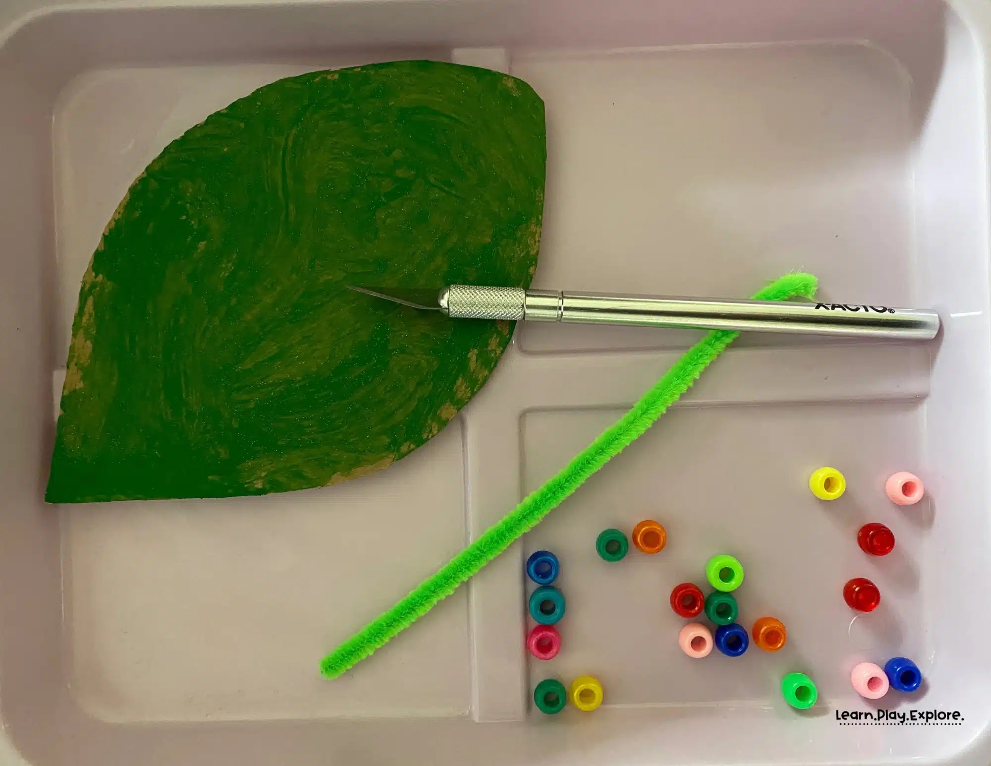 craft your own caterpillar on a leaf with cardboard, pipe cleaners, and pony beads
