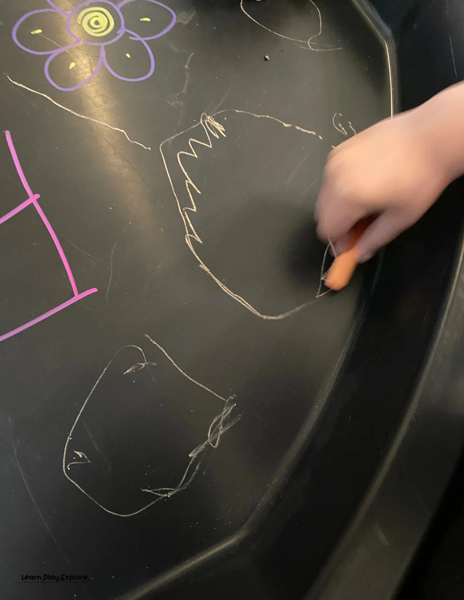 2 year old drawing with chalk on tuff tray