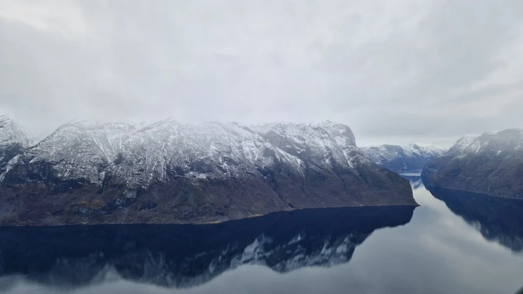 Panoramic view of Aurlandsfjord surrounded by snow-covered mountains, taken from Stegastein Viewpoint - showcasing one of the most beautiful fjords in Norway.