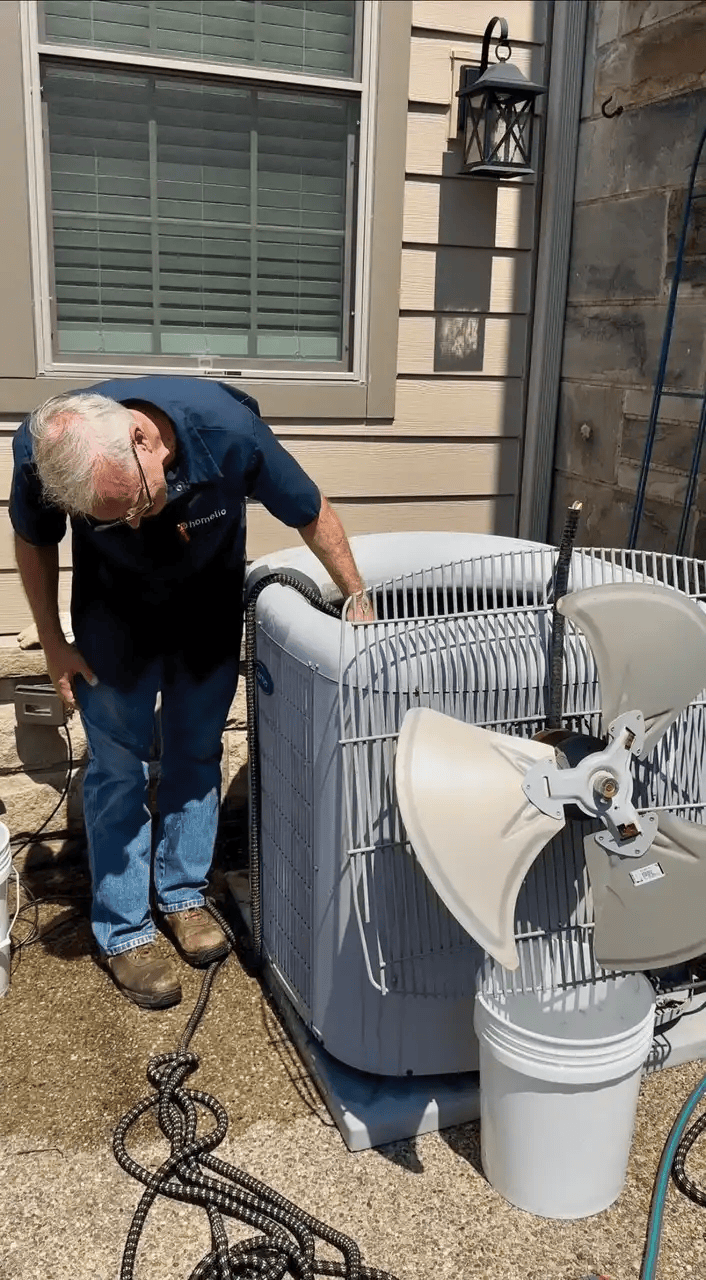 Dave Sienerth, Homelio technician performs routine maintenance on an air-conditioning unit.(Photo by Stacey Reibach)