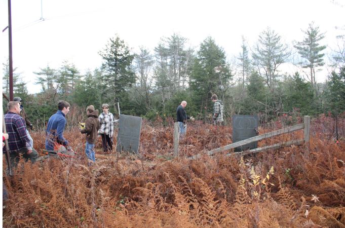 Volunteers help to clear the Wood Family Cemetery in Rindge as part of Kyle Paolino's Eagle Scout community service project. COURTESY