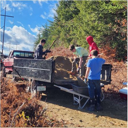 Volunteers unload mulch at the Wood Family Cemetery in Rindge. COURTESY