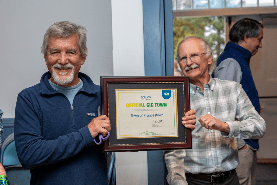 Francestown Broadband Committee Chair Alfred Eisenberg and Selectman Scot Heath celebrate Francestown’s 100% fiber coverage and earning the designation of Gig Town, with Fidium.