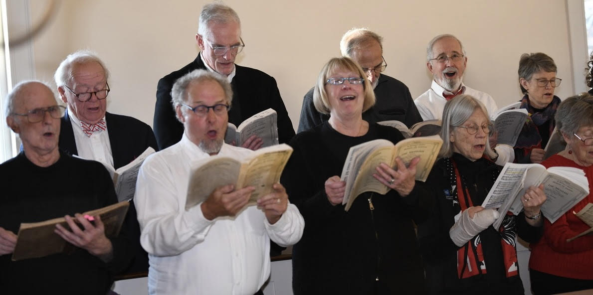 Community singers perform the Christmas section of Handel's "Messiah" on Dec. 6 in the Peterborough Unitarian Universalist Church. Left to right: backrow: Bill Schofield, Mike Gordon, Bill Mitchell, Dick Ernst, Joy Flemming front row: David Flemming, Walden Whitman, Laurie Lewis, Tori Haring Smith, Mary Ellen Bushnell