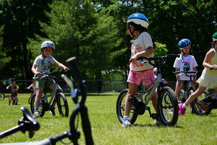 Abbot-Downing first graders Myrton Fellows, left, Violet Ruiz, right, and others honing their bicycle skills in gym class at the end of May.