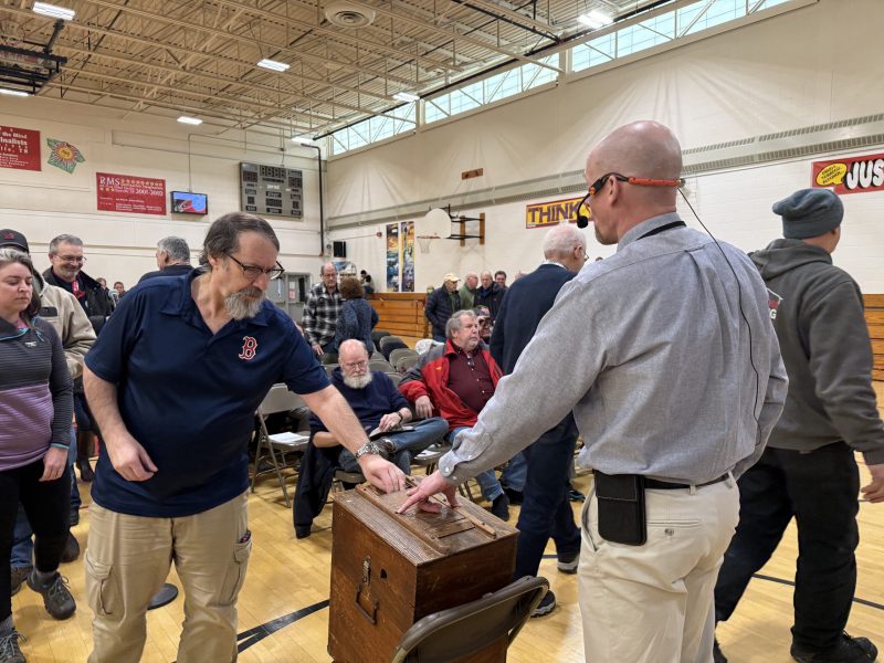 Resident Phil Motta casts a vote on an offered amendment. ASHLEY SAARI / Ledger-Transcript