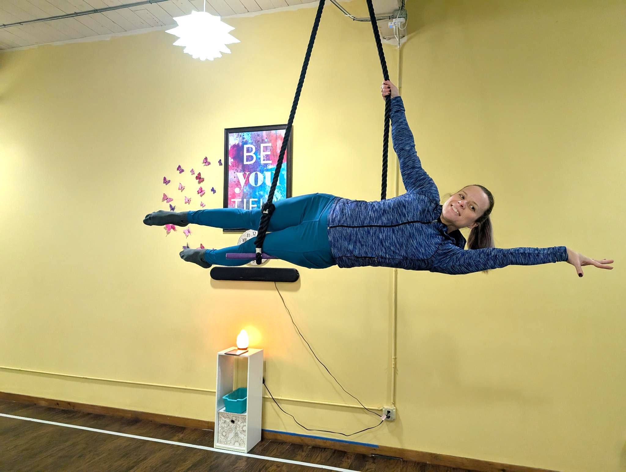Jackie Wydra, Fit to Fly LLC owner and aerial instructor, holds the key pose while hanging from a trapeze bar.