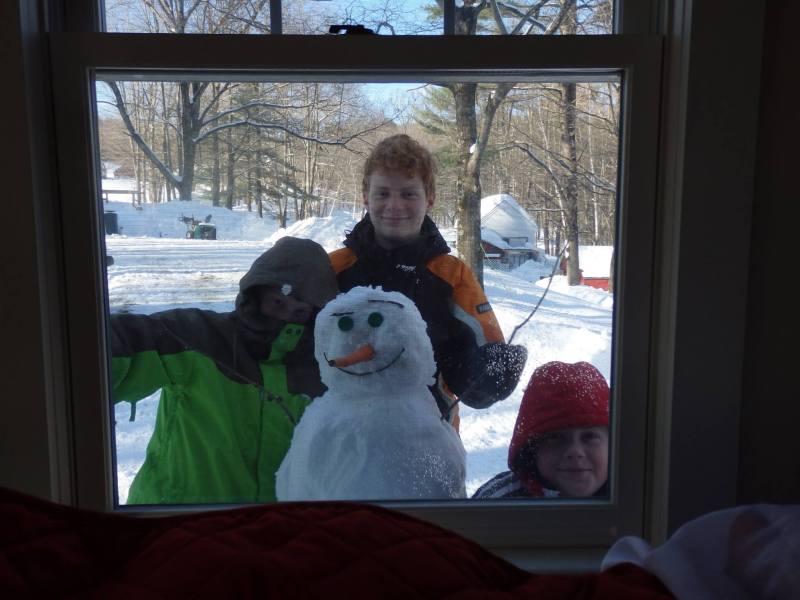 Brothers Nathaniel, 12, Noah, 11, and Joshua 8, Simard built a snowman just outside the window to cheer up their mother, Karin Simard, who was watching from indoors, sick with the flu. KARIN SIMARD / Courtesy