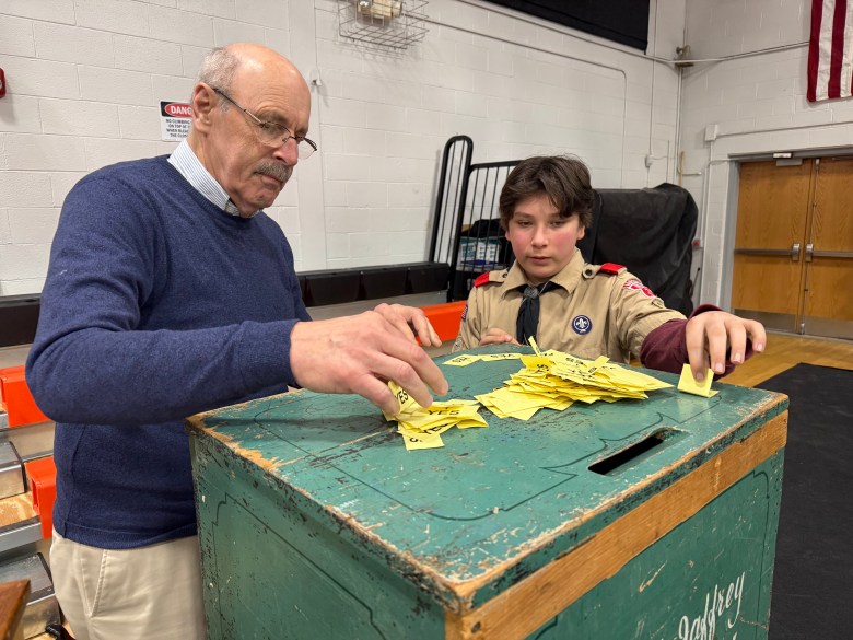 Bob Schaumann and scout Grant Johnson count ballots cast for the fire station bond. ASHLEY SAARI / Ledger-Transcript