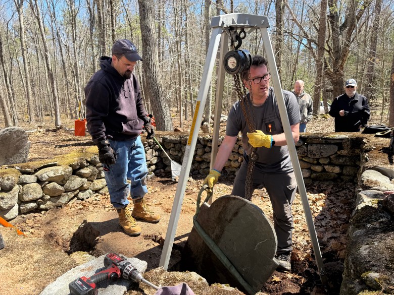 Volunteer Walter Gruda and Kai Nalenz work to remove Susannah Rand's gravestone.