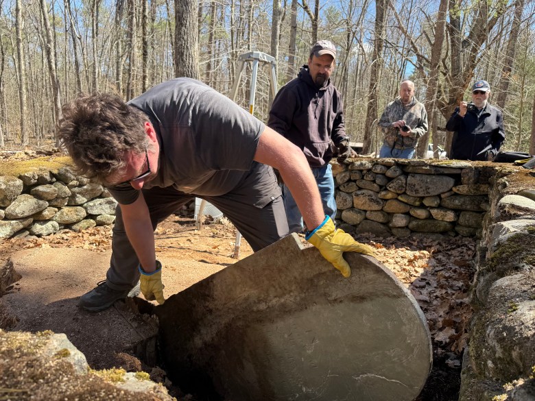Kai Nalenz of Gravestone Services of New England works to remove Susannah Rand's gravestone.
