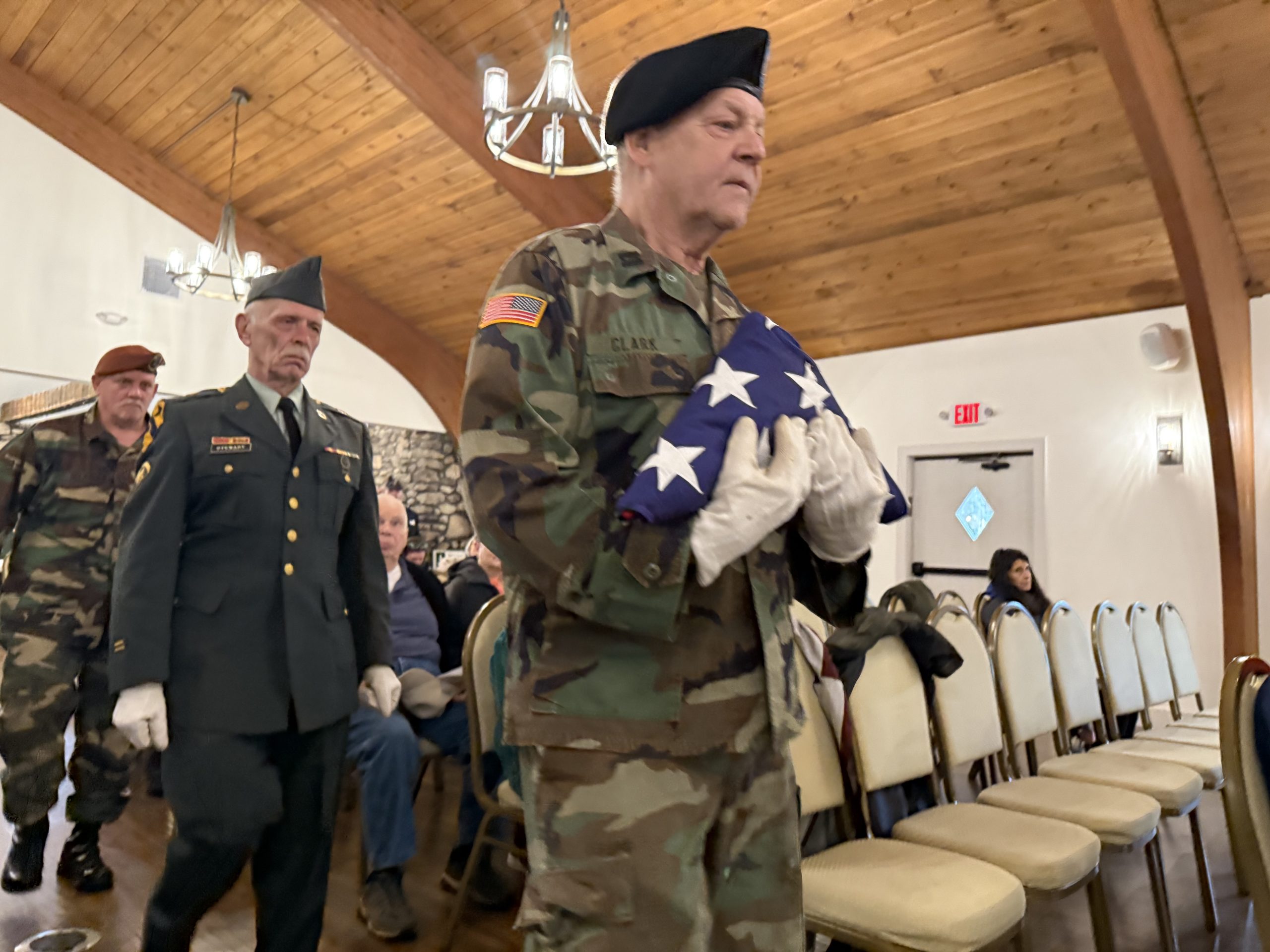 Rindge Veterans Association members Craig Clark, right, Paul Steward and Jeff Selander carry an American flag to the front of the room for a folding a presentation of the flag in honor of Don Nelson.