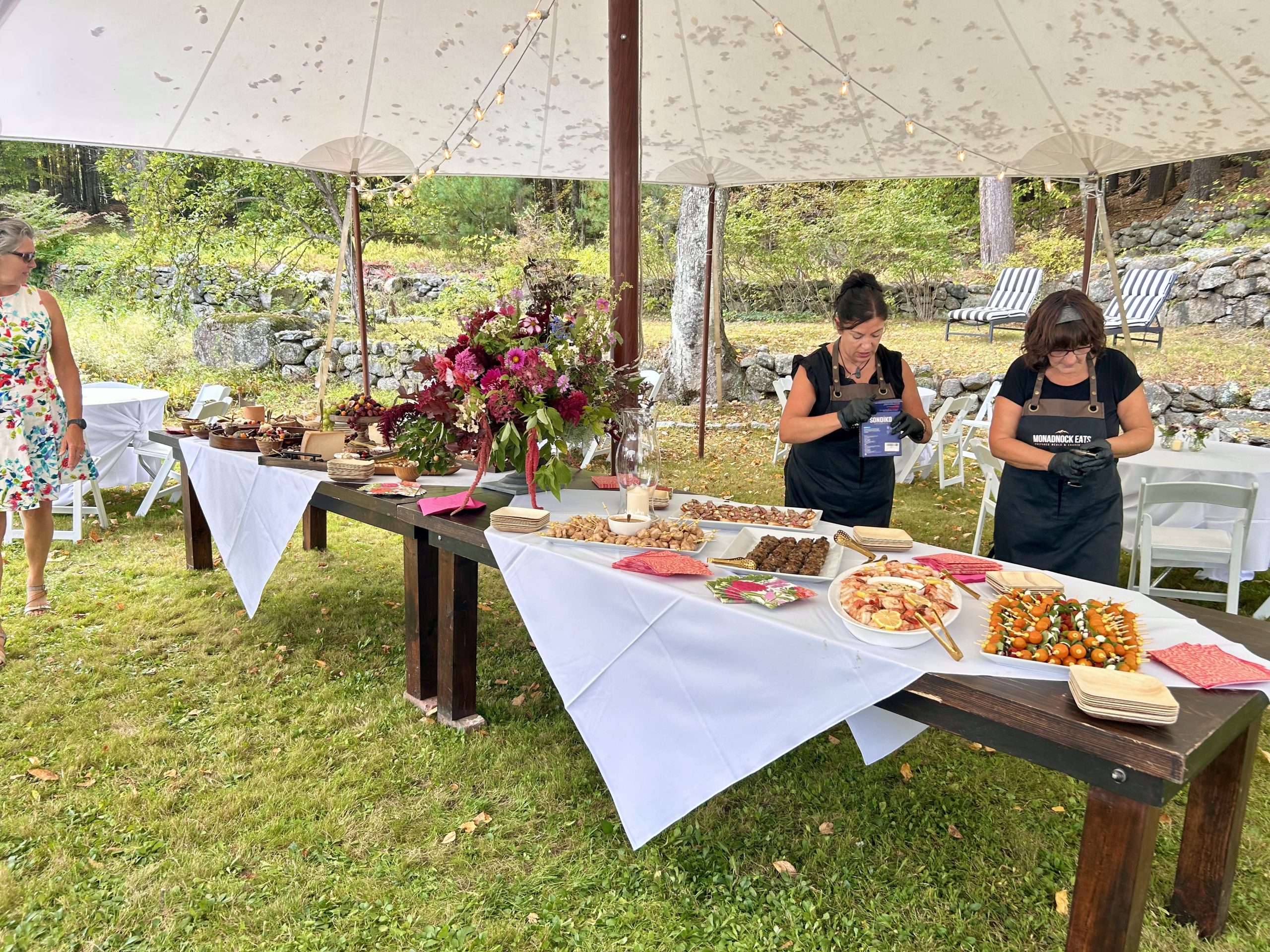 Monadnock Eats Catering Manager Deb Golden and of servers Delilah Daisy set up a catering table at a wedding.