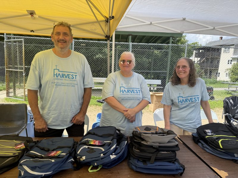 Harvest Fellowship volunteers Cliff Tallant, Laura Thibault and Cindy Lafreniere give out free backpacks to students.