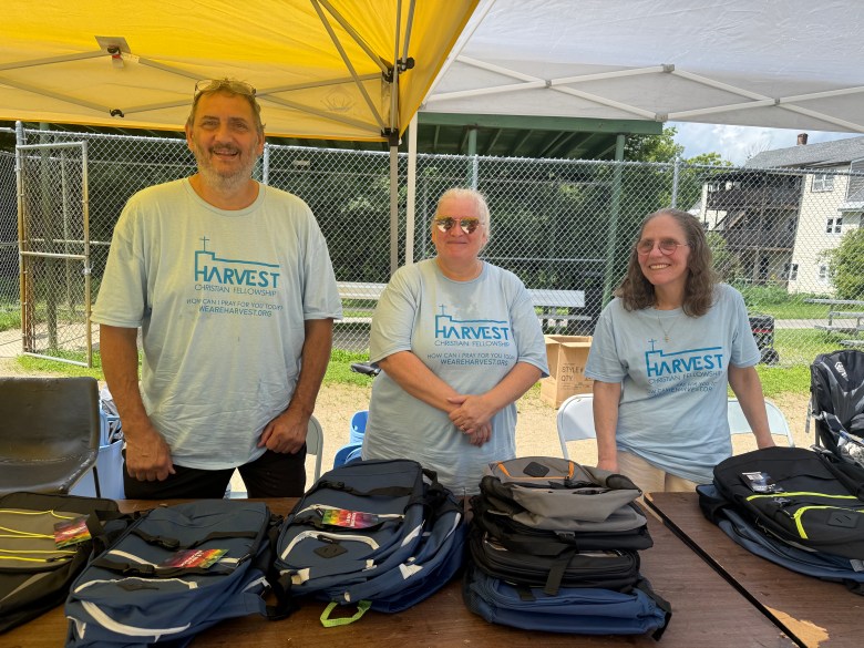 Harvest Fellowship volunteers Cliff Tallant, Laura Thibault and Cindy Lafreniere give out free backpacks to students.
