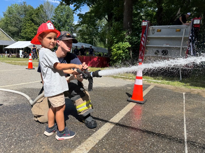 Benny Ginsberg of Ashby gets a turn on the fire hose at a firefighting game.