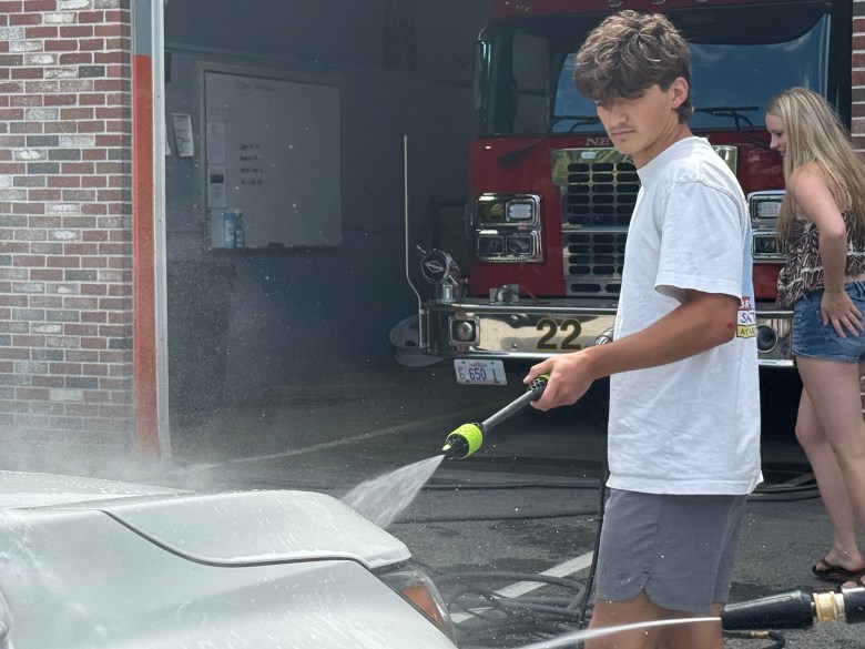 Cayden Emerson sprays down a car at the car wash.