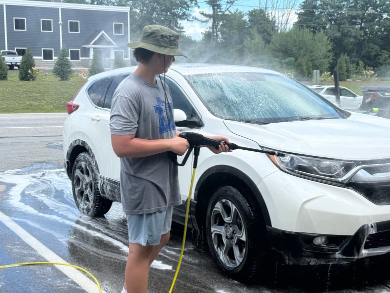 Reed Carignan gives a car a final rinse.