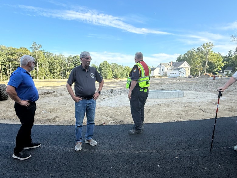 Members of the Select Board and the public walk a road on a proposed development on Main Street.