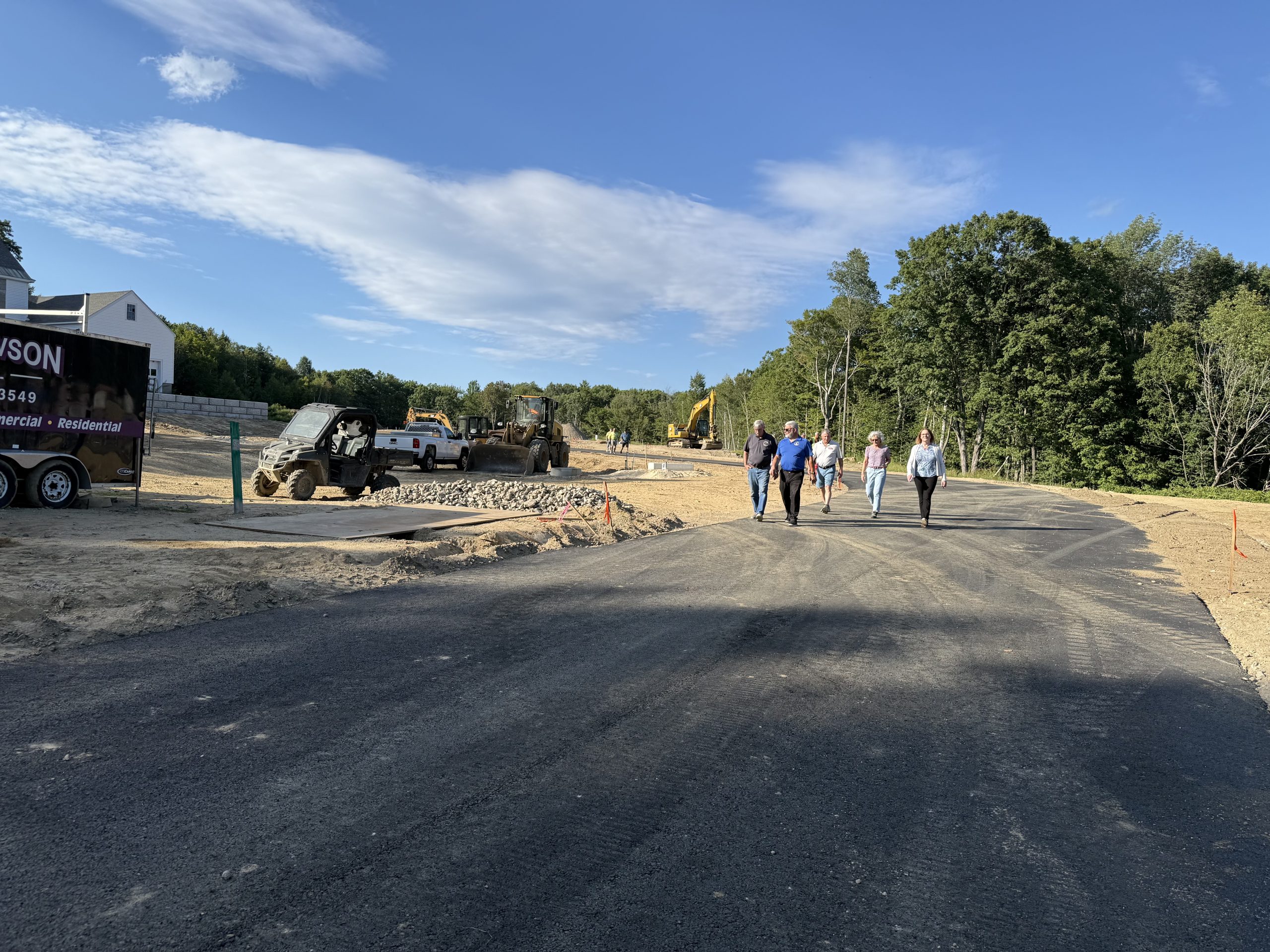 Members of the Select Board and the public walk a road on a proposed development on Main Street.