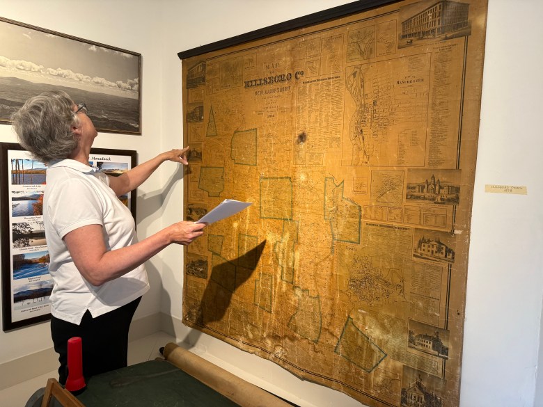 Village Improvement Society member Sara Hamlen examines a historical county map.