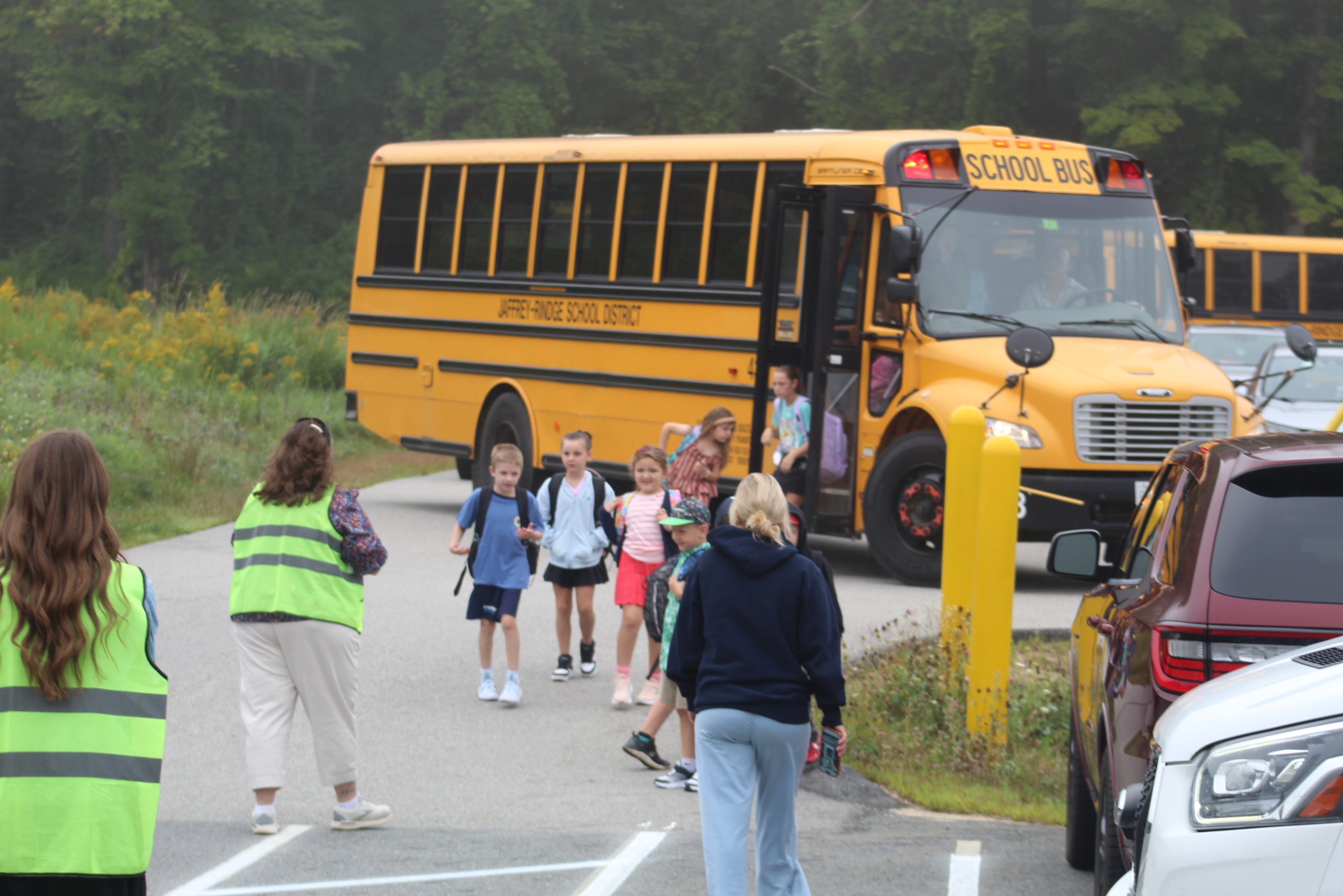 Teachers welcome students off the bus on the first day of school at Rindge Memorial School.