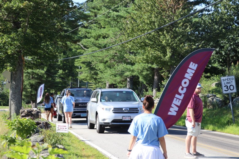 Cars dropping off new students line up at the campus Four Corners.