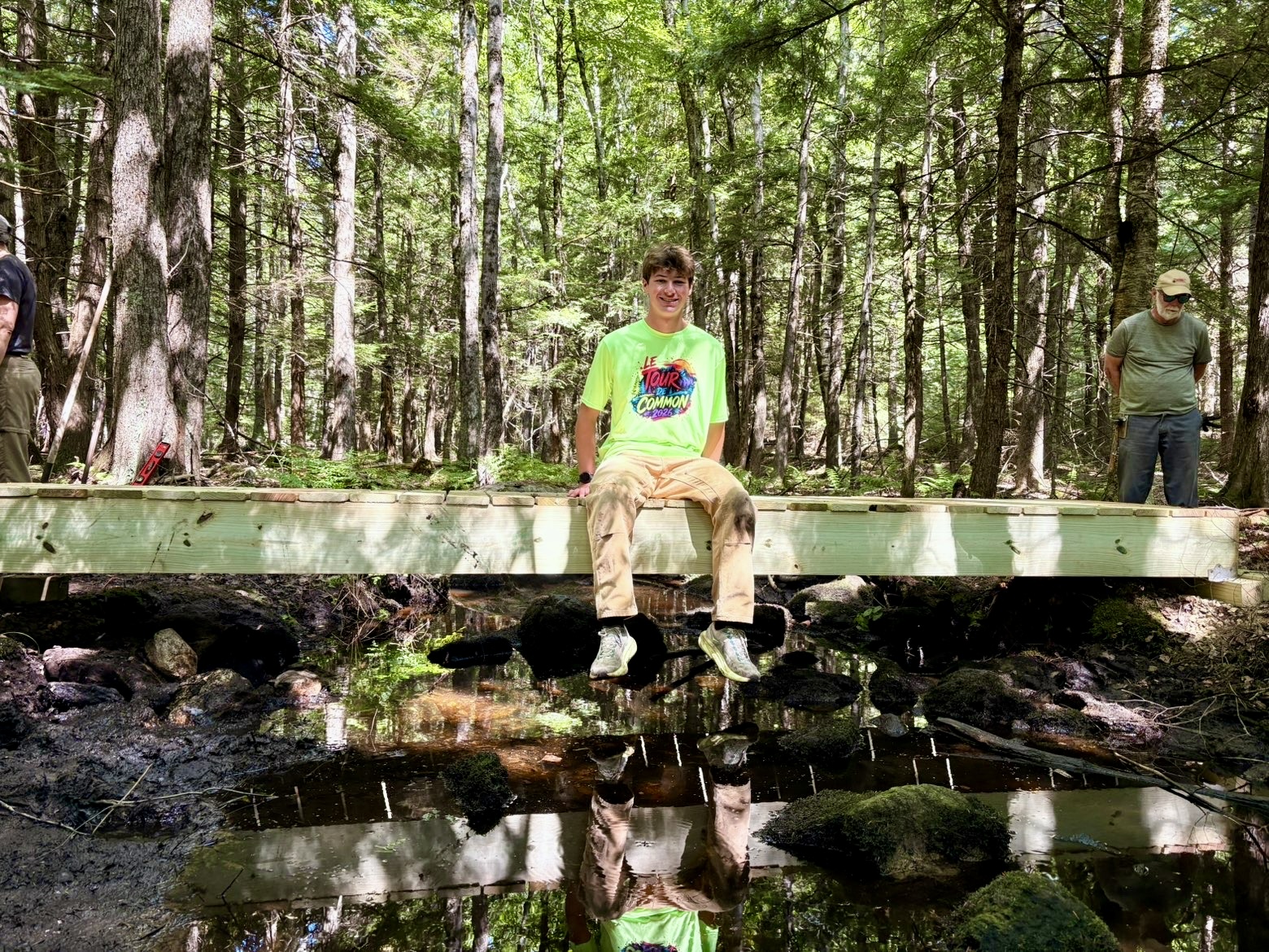 Aaron Graham sitting on the newly finished foot bridge.