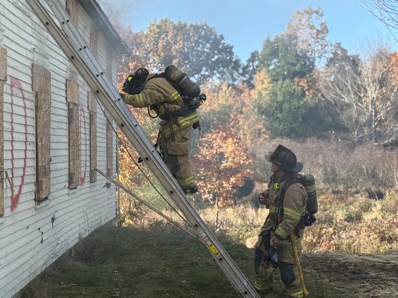 New Ipswich firefighters make their way up a ladder to a second story window entrance.