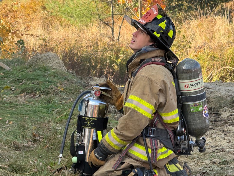 New Ipswich firefighter Ryan Murray stands by with an extinguisher.