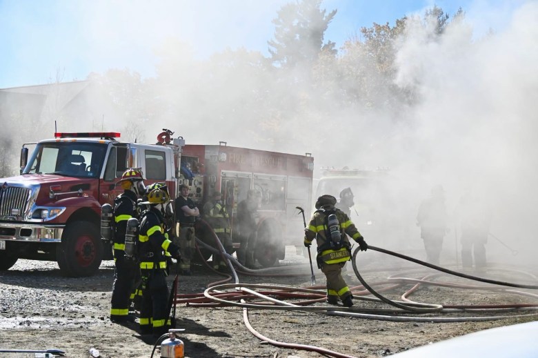 Crews work to advance hoses through smoky conditions.